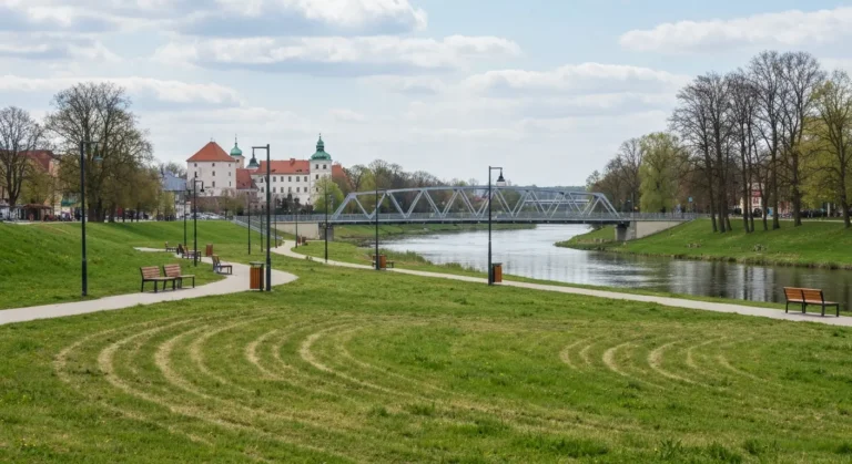 Sciezka spacerowa i lawki na bulwarach nad Wislokiem w Rzeszowie, w tle most i zabudowa starego miasta